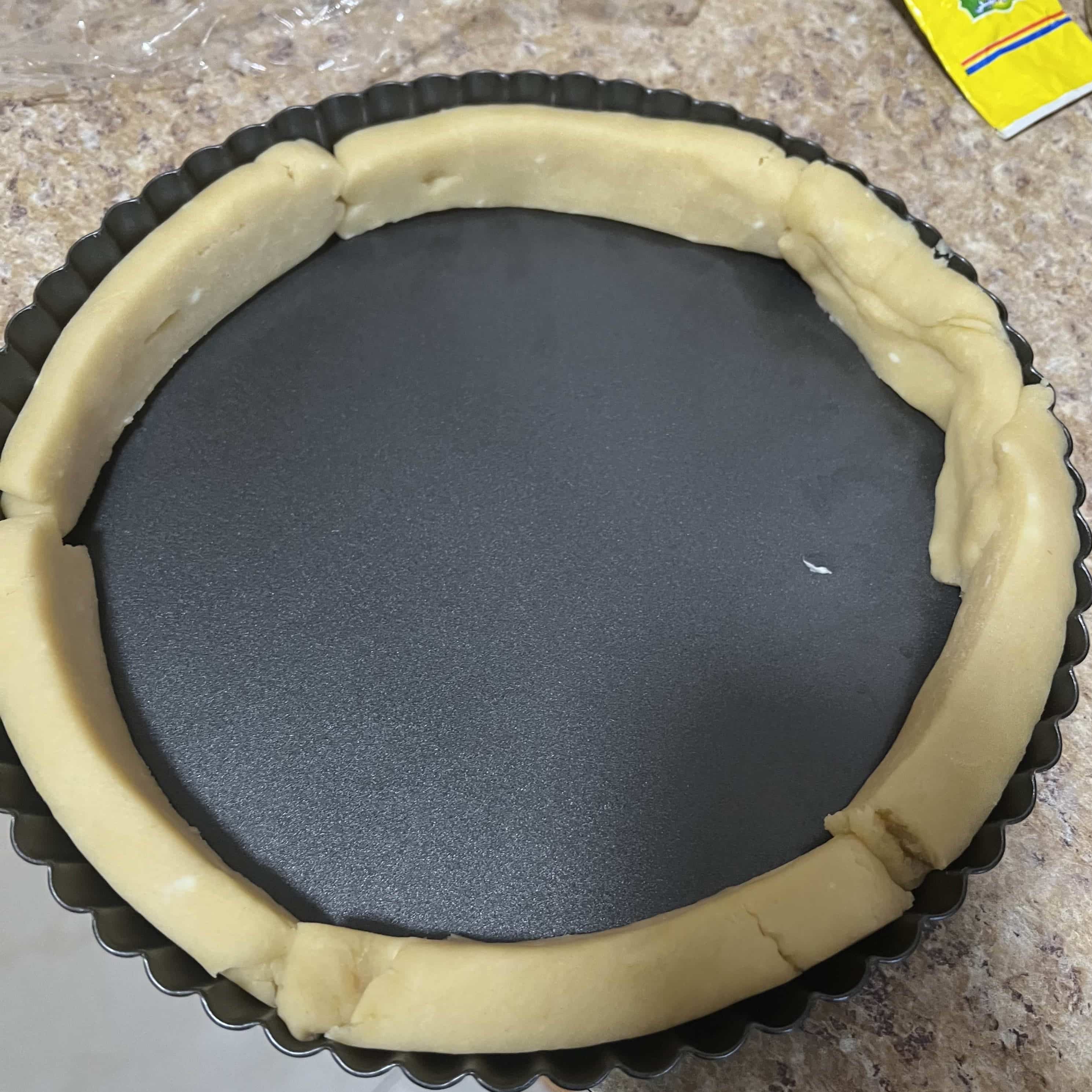 Sweet pastry dough ropes pressed along the tart pan edge